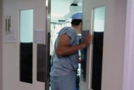 Surgeon opening operating room door 