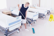Environmental services technician cleaning floor 