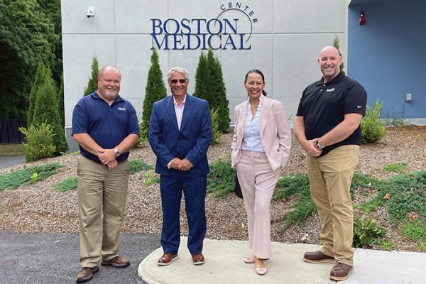 FROM LEFT: Cory Pouliot, senior director of facilities at Boston Medical Center Health System; Bob Biggio, senior vice president and chief sustainability and real estate officer at Boston Medical Center Health System; Nancy Hanright, senior director of real estate and space planning at Boston Medical Center Health System; and Tony McLeish, facilities manager at Brockton Behavioral Health Center. IMAGE COURTESY OF BOSTON MEDICAL CENTER