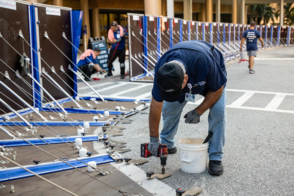 Tampa General Hospital facilities staff anchor the AquaFence into the concrete along the hospital’s perimeter in preparation for hurricane season